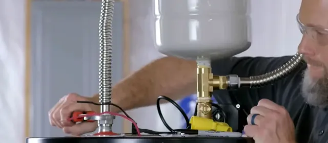 Plumber attaching an expansion tank on a newly installed water heater